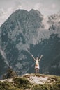 Woman standing at the top of the hill in mountains looking at wonderful scenery. Triglav, the highest slovenian mountain. Trgilav