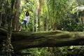 Woman standing on a tree in a tropical forest