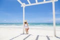 Woman standing under a white pergola looking out at a Beautiful Caribbean beach scene Royalty Free Stock Photo