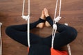 Woman standing upside down practicing yoga on ropes stretching in gym. Fit and wellness lifestyle Royalty Free Stock Photo