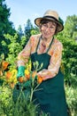 Woman standing watering plants with a happy smile Royalty Free Stock Photo