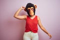 Woman standing wearing t-shirt and monkey mask