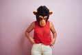 Woman standing wearing t-shirt and monkey mask