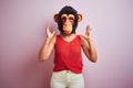 Woman standing wearing t-shirt and monkey mask