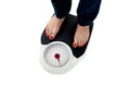 Woman standing on weighing scale, closeup of legs Royalty Free Stock Photo