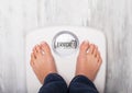 Woman standing on weight scale showing error message Royalty Free Stock Photo