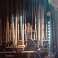 A woman stands in the distance looking at an empty illuminated carousel in a nightly amusement park. Soft focus.