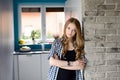 Woman stands in a doorway, next to brick wall Royalty Free Stock Photo