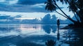 A woman stands at the edge of the shoreline her silhouette against the backdrop of the shimmering water and towering