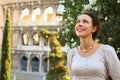 Woman stands near Colosseum and looks up