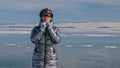 Woman stands near her bike on ice. The girl cyclist stopped to r Royalty Free Stock Photo