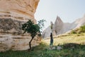 A woman stands next to beautiful rocks and admires the scenery in Cappadocia in Turkey. The landscape of Cappadocia. The Royalty Free Stock Photo