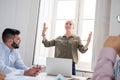 Woman stands in an office with lifted hands