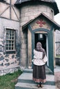 A woman stands praying at the door of an old catholic church Royalty Free Stock Photo