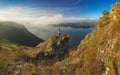 woman stands on a rock above a river canyon. female tourist enjoys foggy autumn landscape