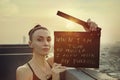 Woman stands on the roof with a poster `When I am true to myself, I align with my purpose` International Womens Day concept.