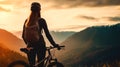 Woman stands with sports bike at mountain top on sunset sky background