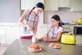 Woman stands at table and pouring milk in glass cup. Girl stands besides her mother and looks at it. She holds heer cup Royalty Free Stock Photo