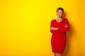 a woman stands on a yellow background and folds her hands Royalty Free Stock Photo