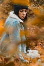 Woman staring through a fall colors forest