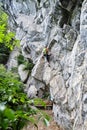Woman starting to climb a difficult via ferrata route called Zimmereben rated D/E, near Mayrhofen, Zillertal valley, Austria