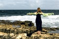 Woman staying at the seashore , windy day