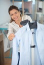 woman steaming blue shirt in room Royalty Free Stock Photo