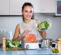 Woman steaming salmon and vegetables Royalty Free Stock Photo