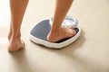 Woman stepping on floor scales. Overweight problem