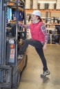 Woman stepping up into fork lift truck Royalty Free Stock Photo