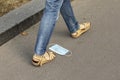 A woman steps on a medical mask lying on sidewalk. Coronavirus garbage, quarantine waste concept.