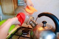 Woman sterilize a glass jar with steam from a teapot