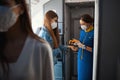 Cabin crew female holding temperature gun above female hand