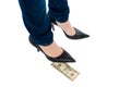 Woman in stilettos standing over ten dollar note