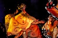 Woman on stilts with fancy butterfly costume in motion at night