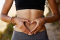 Woman, stomach and hand with heart in outdoor for exercise, diet, fitness and closeup. Female tummy, gut health and self