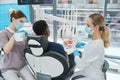 Woman stomatologist waiting nurse making x-ray image of patient teeth