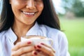 That woman stood happily drinking coffee on the meadow