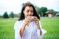 That woman stood happily drinking coffee on the meadow