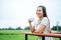 That woman stood happily drinking coffee on the meadow