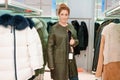 Woman in a store chooses a winter jacket