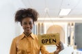 Woman store owner turning open sign broad through the door glass and ready to service. Small business woman owner turning the sign Royalty Free Stock Photo
