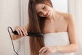 Woman straightening hair with straightener