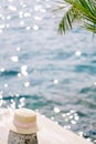 Woman straw hat lies on a bollard on a pier by the sea