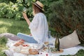 Woman in straw hat on picnic holding a glass of wine from behind. Summer time adventures Royalty Free Stock Photo