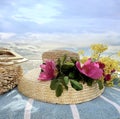 woman straw hat with pink flowers and bag on blue blanket on summer beach summer concept