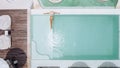 Woman in straw hat relaxing in clear pool water in hot sunny day on Bali villa