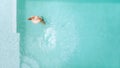 Woman in straw hat relaxing in clear pool water in hot sunny day on Bali villa