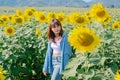 A woman in a straw hat is standing in a large field of sunflowers. stands in flowering field. Summer time, lifestyle, travel and Royalty Free Stock Photo