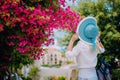 Woman with straw hat and vivid flowers. Amazing summer time on mediterranean sea. Romantic Traveling vacation concept Royalty Free Stock Photo